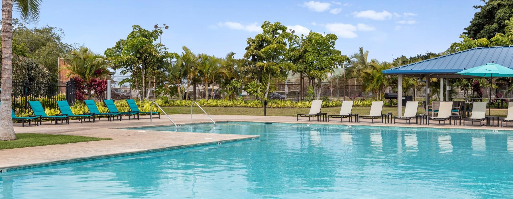 a swimming pool with chairs and umbrellas